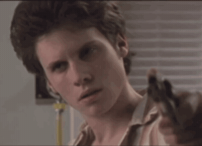 Man In Striped Shirt Holding Gun To Ear GIF