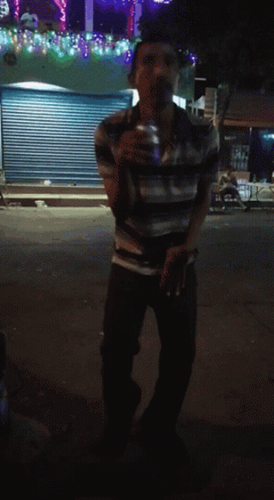 Man In Striped Shirt In Front Of Closed Store GIF
