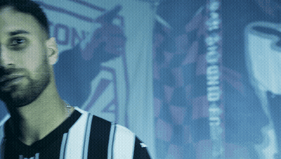 Man In Striped Shirt In Front Of East End Child Sign GIF