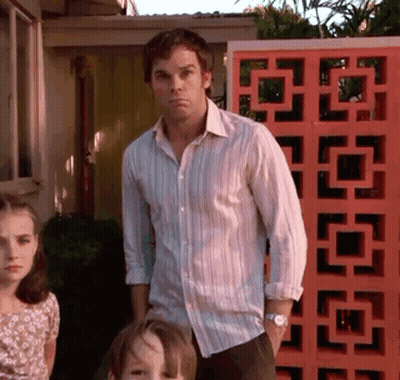 Man In Striped Shirt In Front Of Red Wall GIF