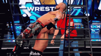 Man In Striped Shirt In Front Of WWE Screen GIF