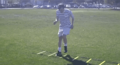Man In Striped Shirt Jumping Over Ladder GIF