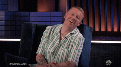 Man In Striped Shirt Laughing With NBC Logo GIF