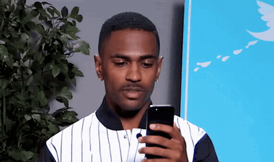 Man In Striped Shirt Looking At Cell Phone GIF