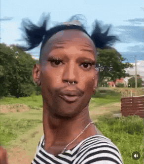 Man In Striped Shirt Making Funny Face In Field GIF