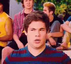 Man In Striped Shirt Making Funny Face To Group GIF