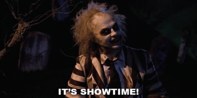 Man In Striped Shirt Says It's Showtime In Front Of Cemetery GIF