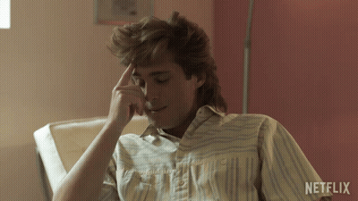 Man In Striped Shirt Sitting Before Netflix Wall GIF