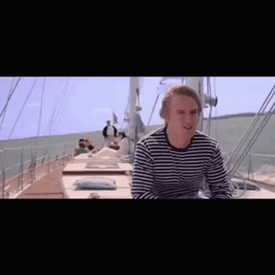 Man In Striped Shirt Sitting On Boat In Ocean GIF