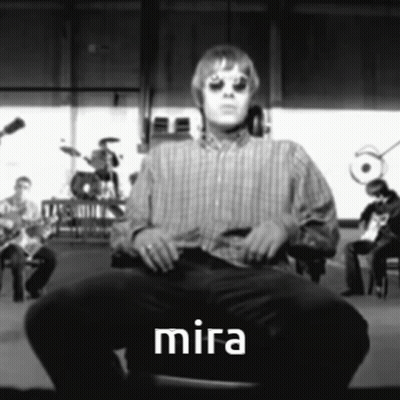 Man In Striped Shirt Sitting On Chair With Word Mira GIF