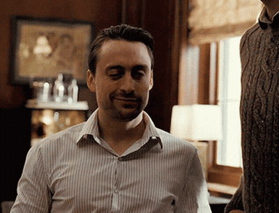 Man In Striped Shirt Smiling At Window GIF