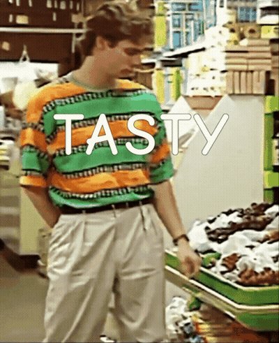 Man In Striped Shirt Standing In Front Of Shelf Saying Tasty GIF