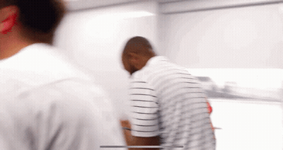 Man In Striped Shirt Standing In Room GIF