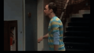 Man In Striped Shirt Standing Next To Door And Stairs GIF