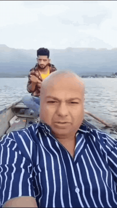 Man In Striped Shirt Taking Selfie On Boat GIF