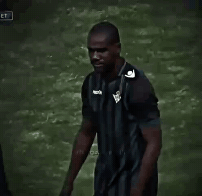 Man In Striped Shirt Talking To Another Man On Soccer Field GIF