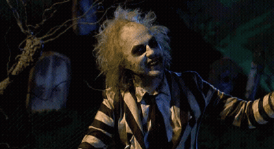 Man In Striped Suit Standing In Cemetery GIF
