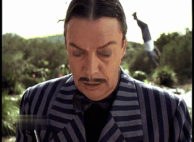 Man In Striped Suit With Mustache Looking Down GIF