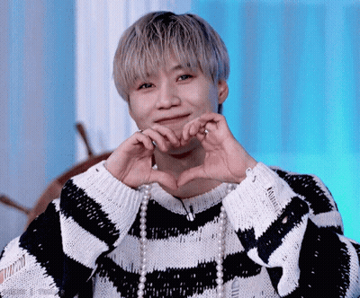Man In Striped Sweater And Pearls Making Heart Shape GIF