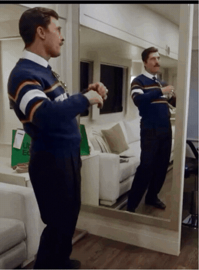 Man In Striped Sweater Holding Wine In Front Of Mirror GIF