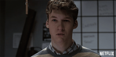 Man In Striped Sweater In Front Of Netflix Board GIF