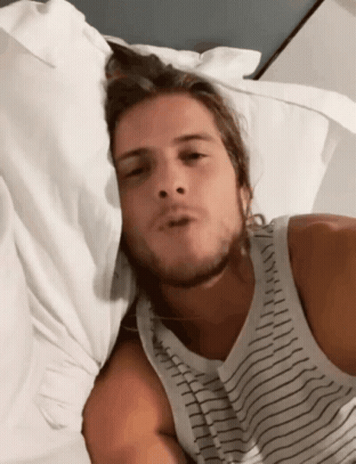 Man In Striped Tank Top Laying In Bed GIF