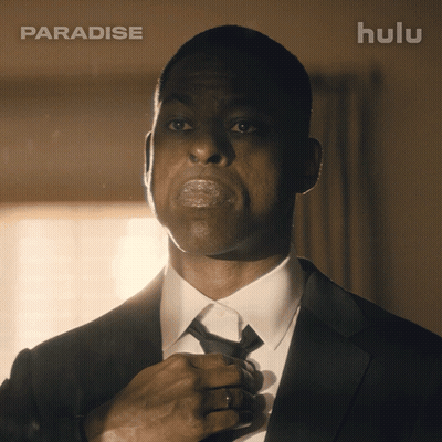 Man In Suit Adjusting Tie In Front Of Hulu Ad GIF