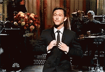Man In Suit Adjusting Tie On Stage GIF