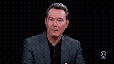 Man In Suit And Black Shirt In Front Of Comedy Central GIF