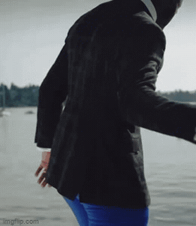 Man In Suit And Blue Pants Standing By Water GIF
