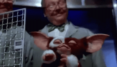 Man In Suit And Bow Tie Holding Stuffed Animal GIF