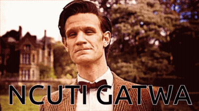 Man In Suit And Bow Tie In Front Of Ncuti Gatwa Sign GIF