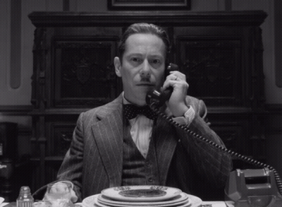 Man In Suit And Bow Tie Talking On Phone GIF