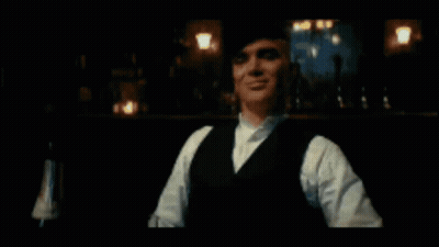 Man In Suit And Bow Tie Walking Down Street With Netflix Logo GIF