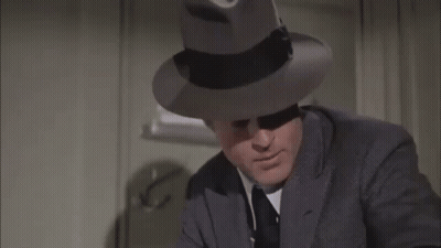 Man In Suit And Fedora Making Funny Face GIF
