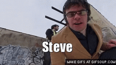 Man In Suit And Glasses Beside Steve Wall GIF