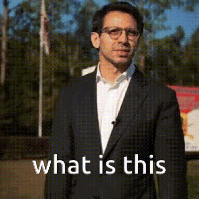 Man In Suit And Glasses Says What Is This GIF