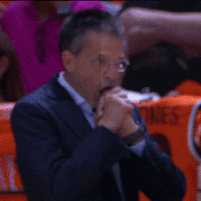 Man In Suit And Glasses Sits With Woman In Orange ACG Shirt GIF