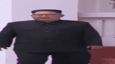Man In Suit And Glasses Standing In Room GIF