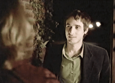 Man In Suit And Green Shirt In Front Of Brick Wall GIF