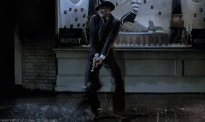 Man In Suit And Hat Dancing By Ahout Sign GIF