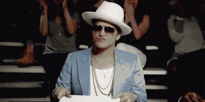 Man In Suit And Hat Holding Paper In Front Of Crowd GIF