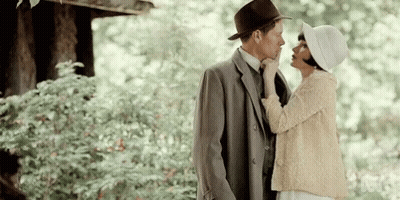 Man In Suit And Hat Kissing Woman In White Hat GIF