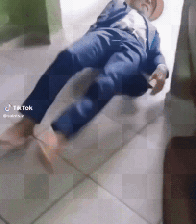 Man In Suit And Hat Laying On Floor With TikTok Watermark GIF