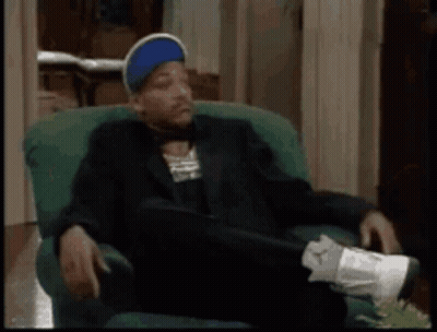 Man In Suit And Hat Sitting With Crossed Feet GIF