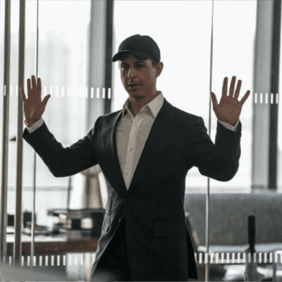 Man In Suit And Hat Standing In Front Of Glass Wall GIF
