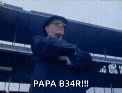 Man In Suit And Hat Standing In Front Of Stadium Arms Crossed Says Papa B34r GIF