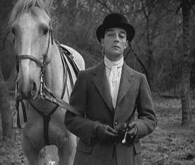 Man In Suit And Hat Standing Next To Horse GIF
