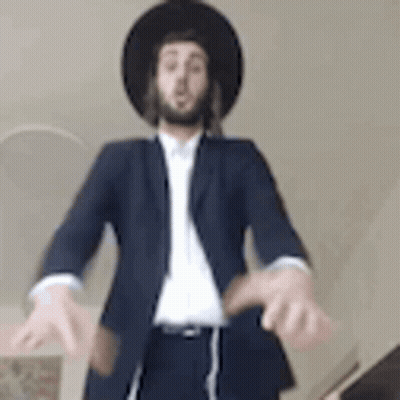 Man In Suit And Hat Standing With Hands Outstretched GIF