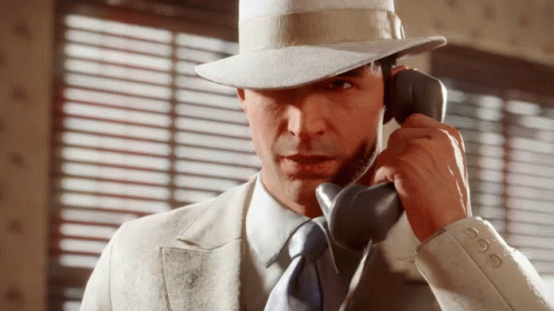 Man In Suit And Hat Talking On Phone GIF